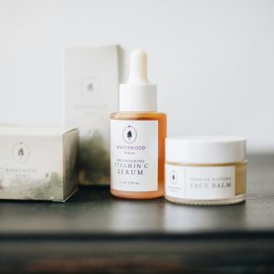 A serene presentation of vitamin C serum and face balm showcasing a minimalist skincare collection.